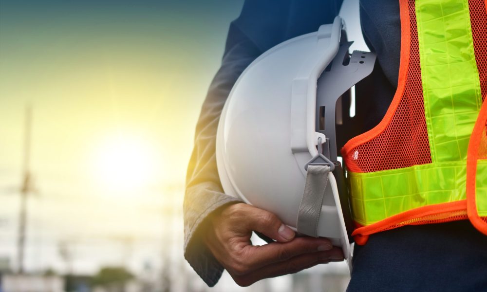 Technician holding white hat safety hard hat